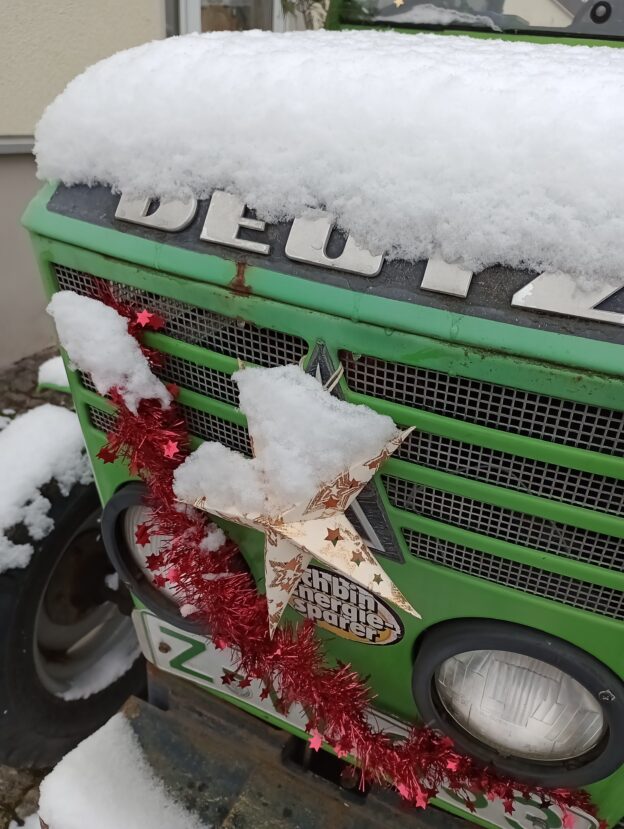 Front eines Traktors, geschmückt mit einem Stern auf dem Schnee liegt.